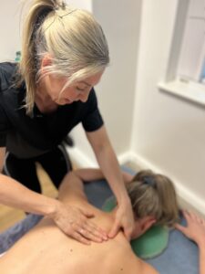 Female massage therapist giving sports massage